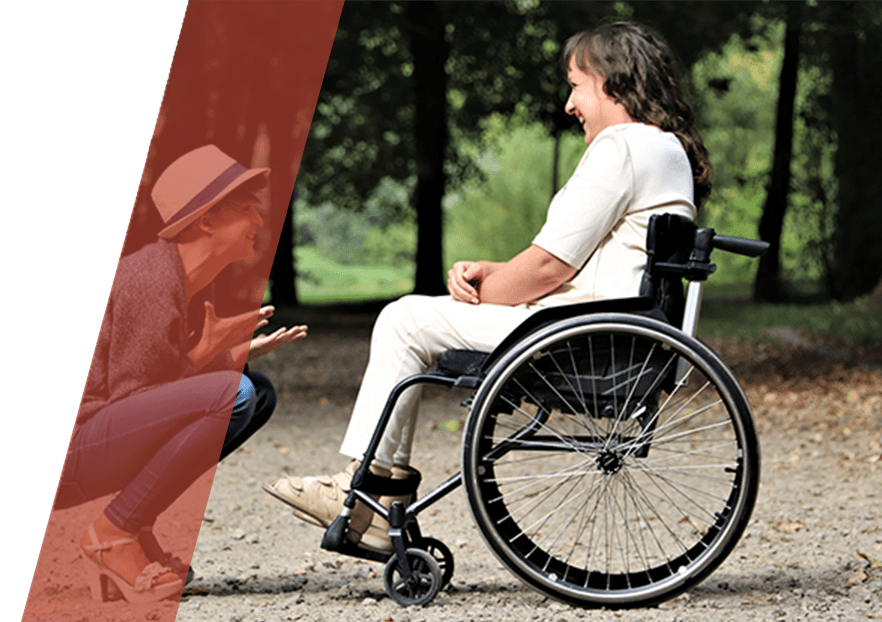 A woman in a wheelchair talking to another person.